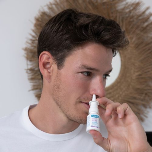 Personne utilisant le spray nasal Quies Anti-Ronflement dans une narine
