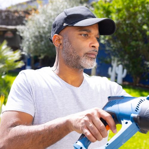 Homme utilisant une perceuse avec les bouchons d'oreilles Quies Specific Bricolage