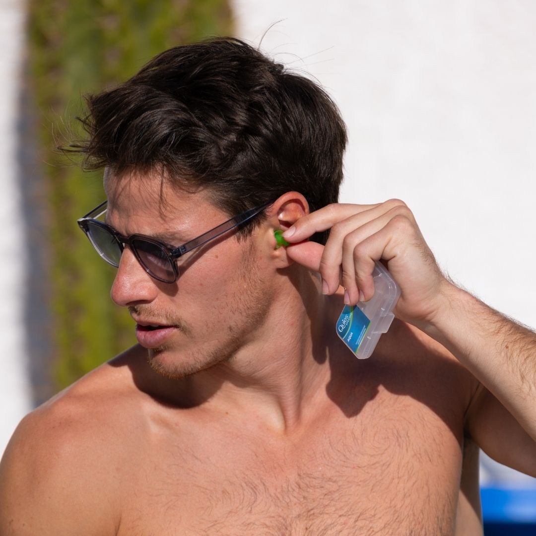 Homme portant un bouchon d'oreille Quies Specific Natation au bord d'une piscine
