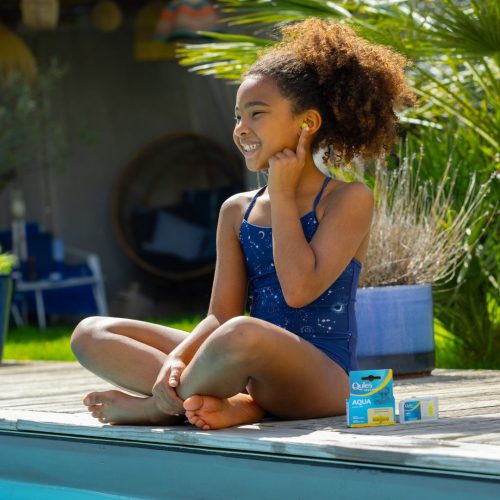 Enfant portant des bouchons d'oreilles Quies Specific Natation au bord d'une piscine